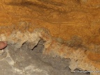 Strefa przejściowa pomiędzy dolomitem (szary kolor w dolnej części) a dedolomitem (od białego po pomarańczowy kolor z brązowymi żyłkami) na ścianie jaskini. Fot. Andrzej Tyc