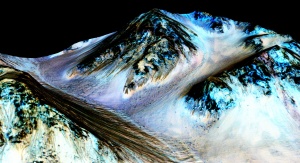 Woda w postaci ciemnych smug na stoku krateru na Marsie. Fot. NASA/JPL/University of Arizona