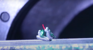 metolowe niewielkie figurki Yody i Dartha Vadera z Gwiezdnych wojen, trzymające laserowe miecze świetlne