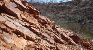 niejednolita formacja skalna, w tle zarośnięte wzgórza