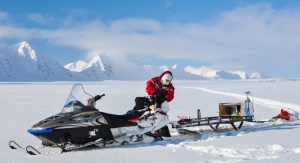 Naukowiec przewożący sprzęt badawczy na saniach śnieżnych