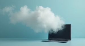 Fot. AI Otwarty laptom na stole, z laptopu unosi się szarobiały dym, błękitnozielonkawe tło | fot. AI