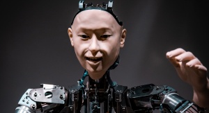 Zdjęcie górnej części ciała humanoidalnego robota. Twarz i dłoń widoczna po prawej stronie stylizowane na ludzkie