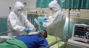 W szpitalu dwóch lekarzy opiekuje się pacjentem chorym na COVID-19