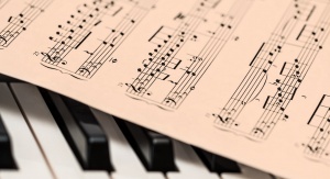 kartka z nutami leżąca na klawiszach fortepianu