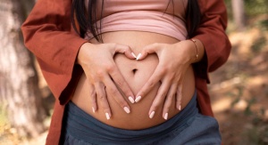 Brzuch kobiety w ciąży. Palce układa na brzuchu w kształcie serca | fot. Freepik