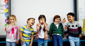 Pięcioro śmiejących się dzieci przy szkolnej tablicy | fot. Rawpixel.com - Freepik.com