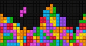 Kolorowe kostki na czarnym tle wzorowane na grze komputerowej "Tetris" | fot. Fotolia 
