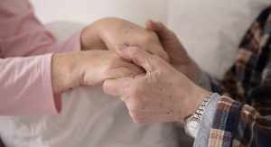 dwie pary rąk osób w podeszłym wieku, trzymających się w geście wsparcia i miłości