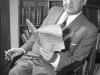 Władysław Broniewski siedzi na krześle z papierosem i książką w rękach