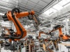 duże ramiona robotyczne pracujące na linii produkcyjnej