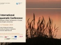 Zdjęcie brzegu jeziora o zachodzie słońca, na które jest nałożona plansza z nazwa konferencji