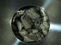 czarne skały przypominające węgiel, schowane w okrągłym pojemniku