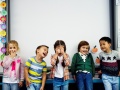 Pięcioro śmiejących się dzieci przy szkolnej tablicy | fot. Rawpixel.com - Freepik.com