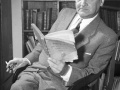 Władysław Broniewski siedzi na krześle z papierosem i książką w rękach