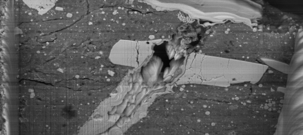 Obraz z skaningowego mikroskopu elektronowego krateru powstałego w wyniku uderzenia mikrometeorytu w cząstkę materiału asteroidy Bennu | Image credit: NASA/Zia Rahman