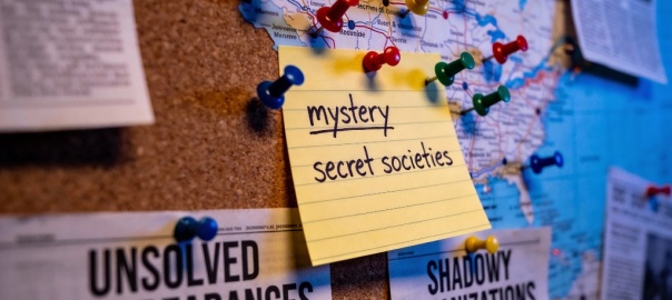 Korkowa tablica, do której kolorowymi pinezkami przyczepiona jest mapa oraz wycinki z gazet | fot. AI