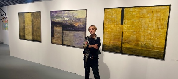 dr Katarzyna Hilszczańska, w tle zawieszone na ścianie trzy obrazy