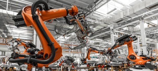 duże ramiona robotyczne pracujące na linii produkcyjnej